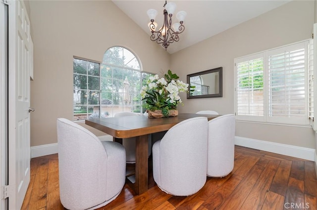 dining area featuring baseboards, lofted ceiling, a notable chandelier, and hardwood / wood-style floors