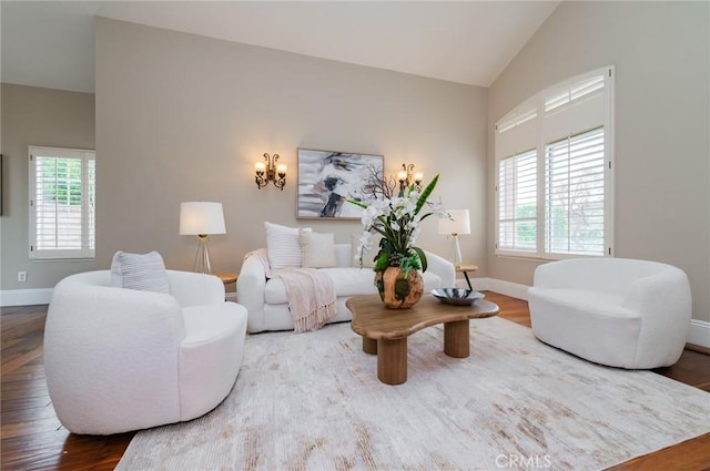 living room featuring vaulted ceiling, wood finished floors, and baseboards