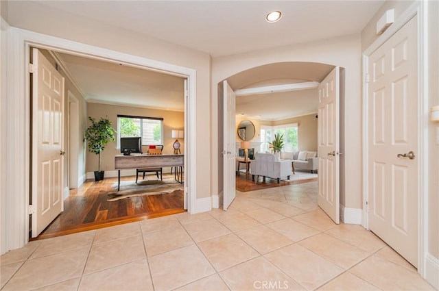 hall featuring recessed lighting, baseboards, arched walkways, and light tile patterned flooring