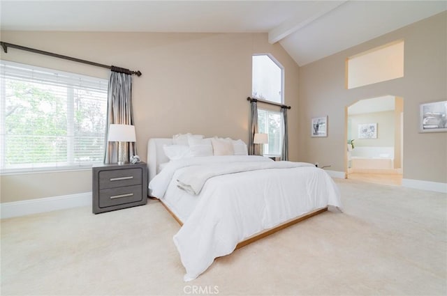 bedroom featuring beam ceiling, multiple windows, arched walkways, and carpet floors