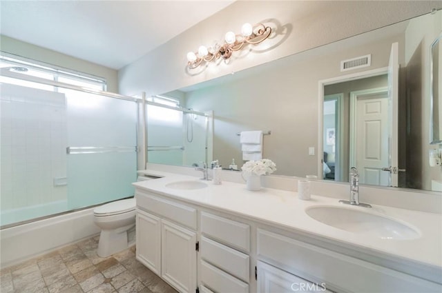 full bath featuring a sink, visible vents, toilet, and double vanity