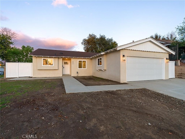 single story home with a garage, concrete driveway, stucco siding, and fence