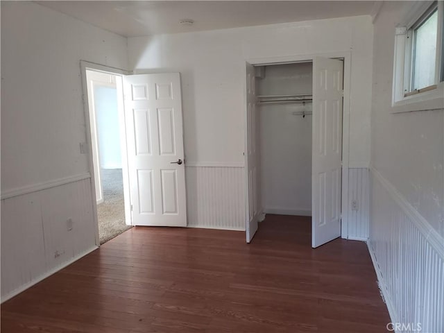 12998 Lakeshore Dr, Clearlake, CA 95422 - unfurnished bedroom featuring wood finished floors, a wainscoted wall, and a closet