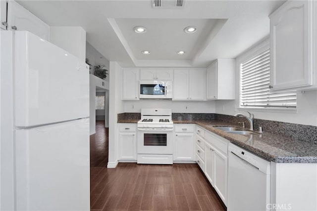 kitchen featuring a sink, recessed lighting, white appliances, a raised ceiling, and dark wood-style flooring