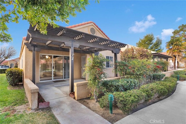 view of front of home with stucco siding and a pergola