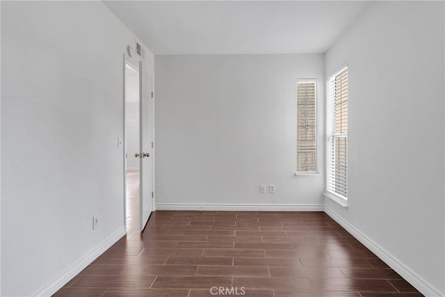 unfurnished room featuring baseboards and wood tiled floor