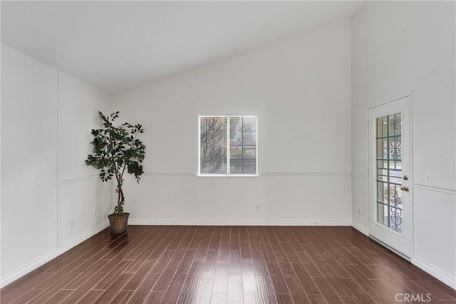 empty room with lofted ceiling, plenty of natural light, and wood finished floors