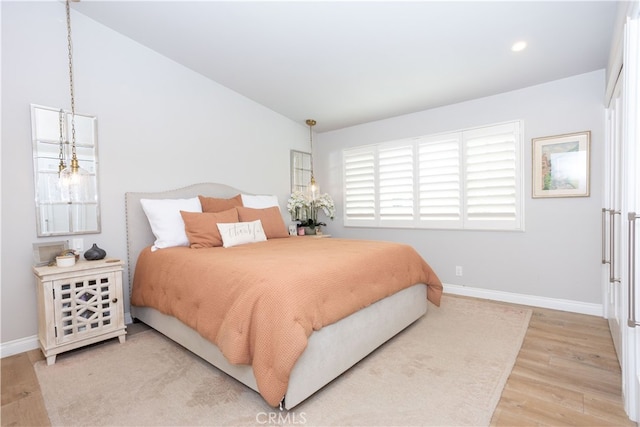 bedroom with recessed lighting, wood finished floors, and baseboards