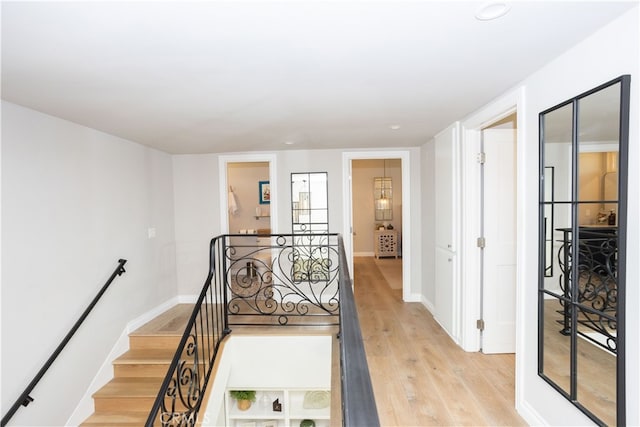 staircase featuring wood finished floors and baseboards