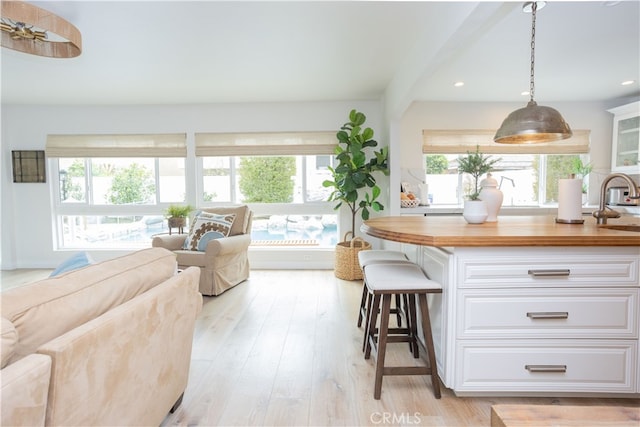 living area with recessed lighting, a healthy amount of sunlight, and light wood-style floors