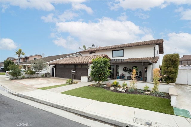 mediterranean / spanish home featuring a tiled roof, stucco siding, driveway, and an attached garage