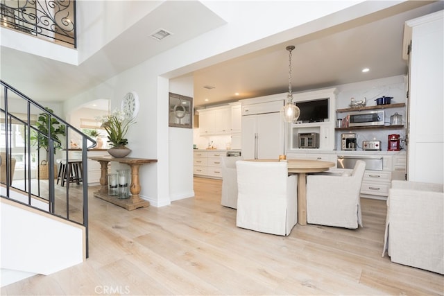 kitchen with light wood-type flooring, visible vents, a center island, white cabinetry, and stainless steel appliances