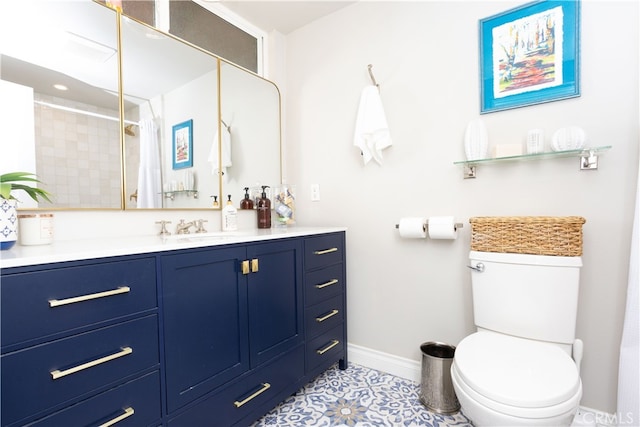 bathroom featuring vanity, tile patterned floors, toilet, and baseboards