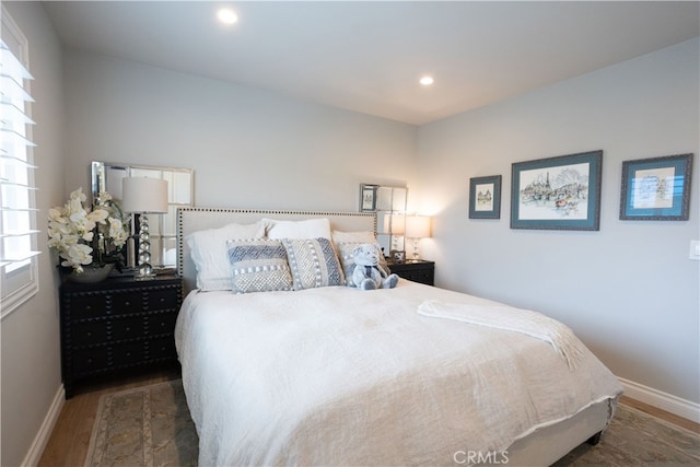 bedroom with recessed lighting, wood finished floors, and baseboards