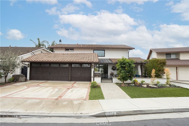 view of front facade featuring a tile roof, a garage, driveway, and stucco siding