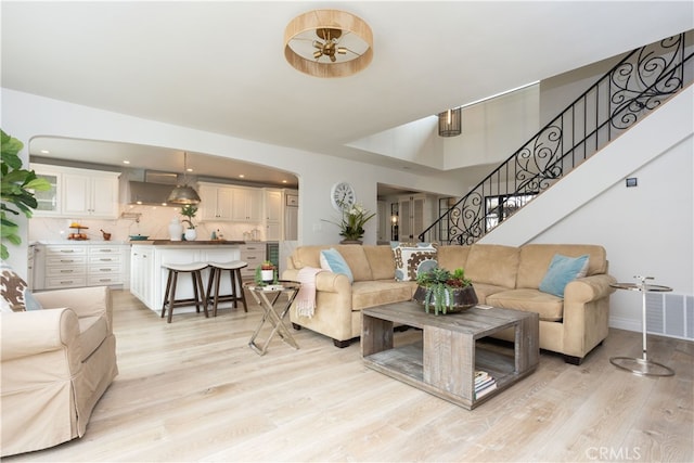 living room featuring stairs, recessed lighting, visible vents, and light wood finished floors