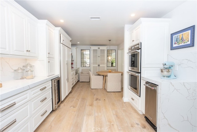 kitchen featuring visible vents, backsplash, double oven, and white cabinetry