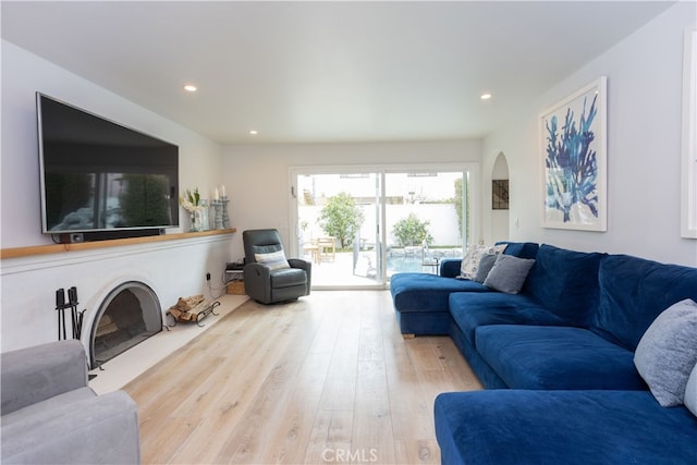 living room featuring arched walkways, recessed lighting, and wood finished floors