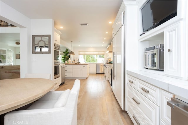 kitchen featuring visible vents, white cabinetry, recessed lighting, light wood-style floors, and appliances with stainless steel finishes