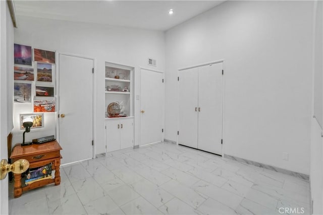 foyer featuring visible vents, marble finish floor, high vaulted ceiling, and baseboards