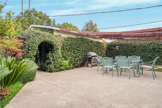 view of patio with outdoor dining area, a grill, and a pergola