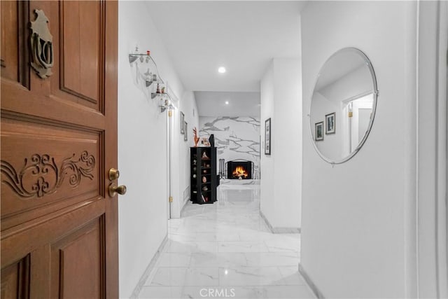 hallway with recessed lighting, marble finish floor, and baseboards