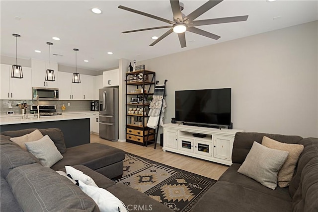 living area with recessed lighting, light wood-type flooring, and ceiling fan