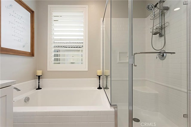 full bathroom with vanity, a shower stall, and a garden tub