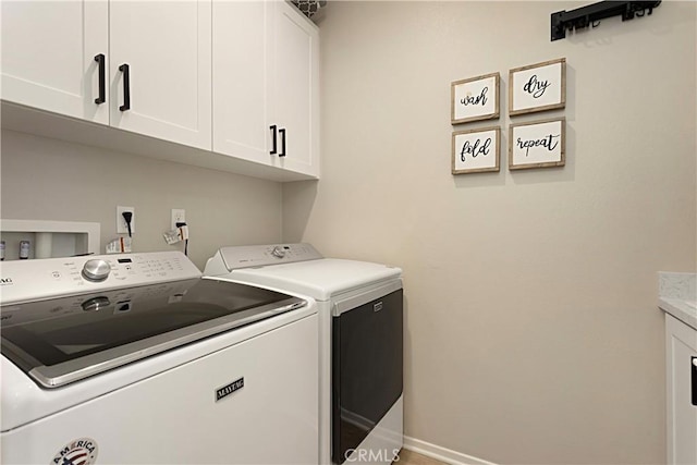 washroom featuring cabinet space, independent washer and dryer, and baseboards