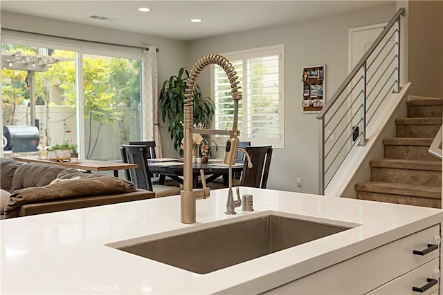 kitchen featuring visible vents, a healthy amount of sunlight, light countertops, and open floor plan