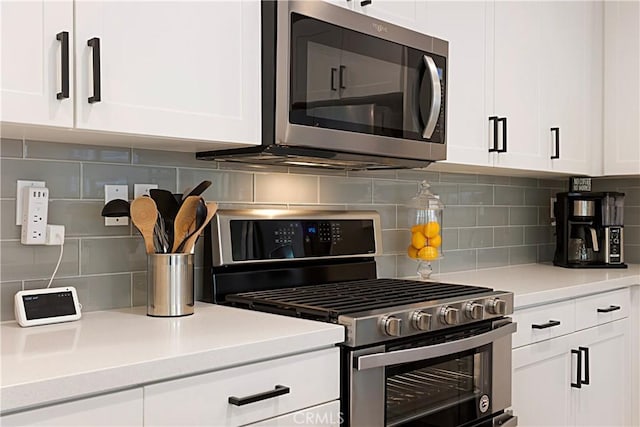 kitchen featuring stainless steel appliances, tasteful backsplash, white cabinets, and light countertops