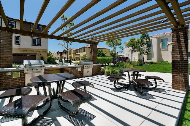 view of patio with exterior kitchen, area for grilling, a pergola, and a residential view