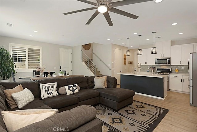 living room with visible vents, ceiling fan, stairs, recessed lighting, and light wood-style floors