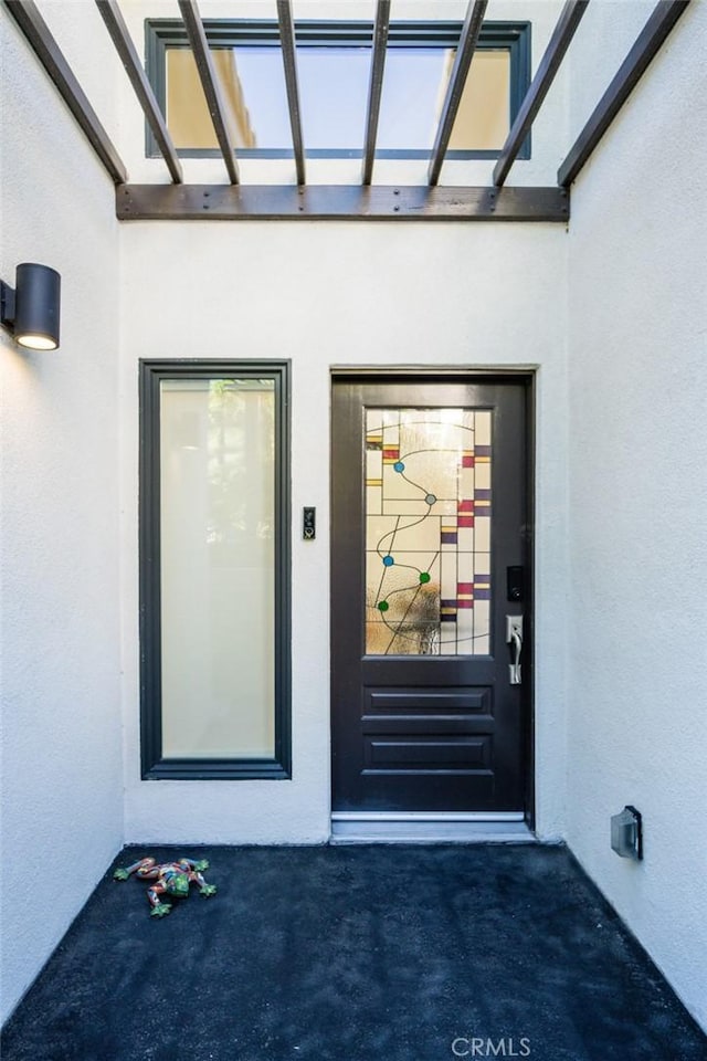 view of exterior entry featuring stucco siding