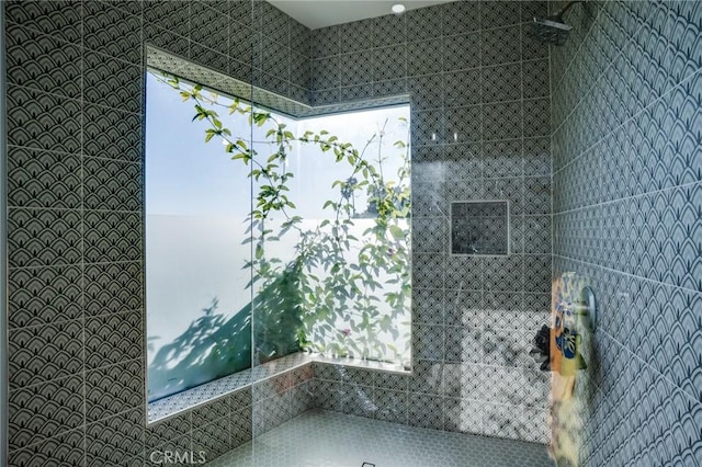 full bath featuring plenty of natural light and a tile shower