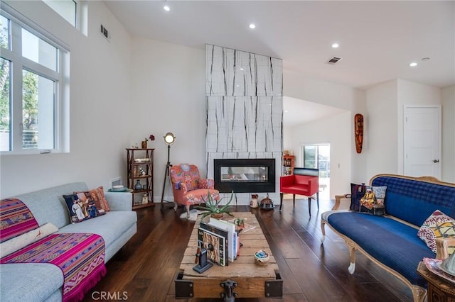 living room featuring a fireplace, recessed lighting, wood finished floors, and visible vents