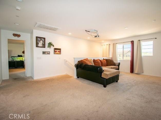living area featuring recessed lighting, light colored carpet, and visible vents