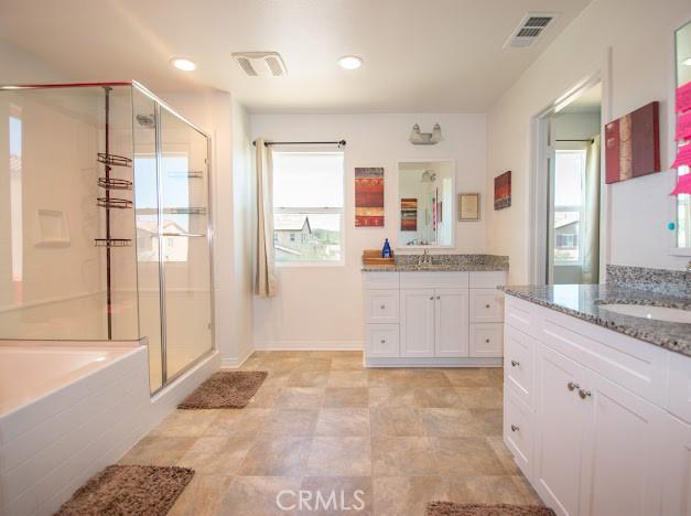 36626 Sevilla Way, Beaumont, CA 92223 - bathroom featuring a stall shower, two vanities, a garden tub, and recessed lighting