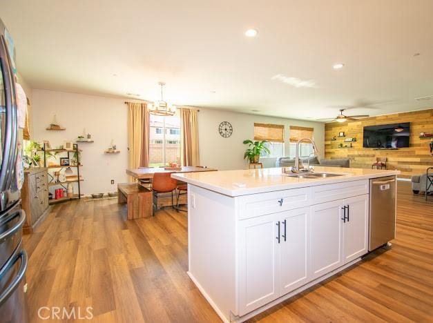 36626 Sevilla Way, Beaumont, CA 92223 - kitchen featuring stainless steel appliances, light wood finished floors, white cabinets, a kitchen island with sink, and light countertops