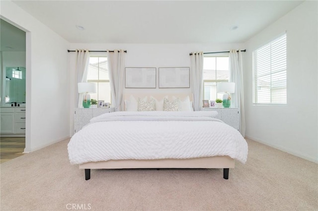 bedroom featuring connected bathroom, baseboards, and carpet