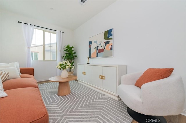 sitting room with visible vents and lofted ceiling