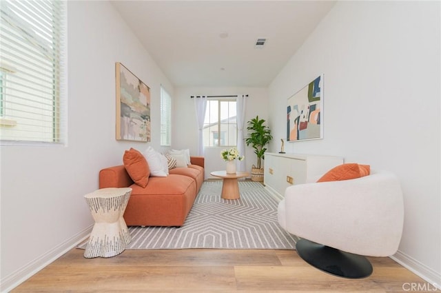 sitting room featuring visible vents, baseboards, and wood finished floors