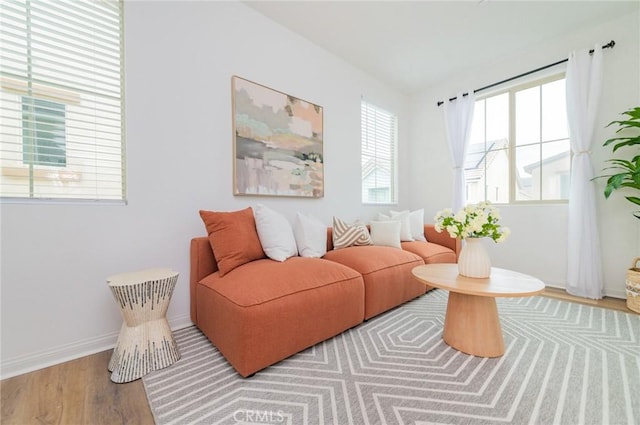 living area with baseboards and wood finished floors