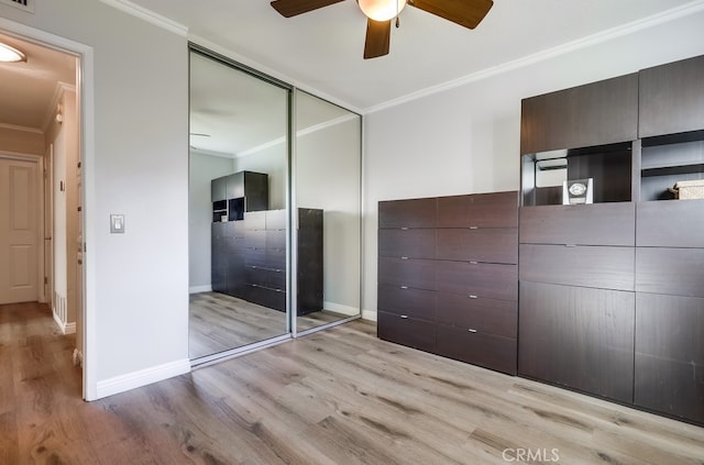 unfurnished bedroom featuring light wood-style flooring, baseboards, a closet, and ornamental molding