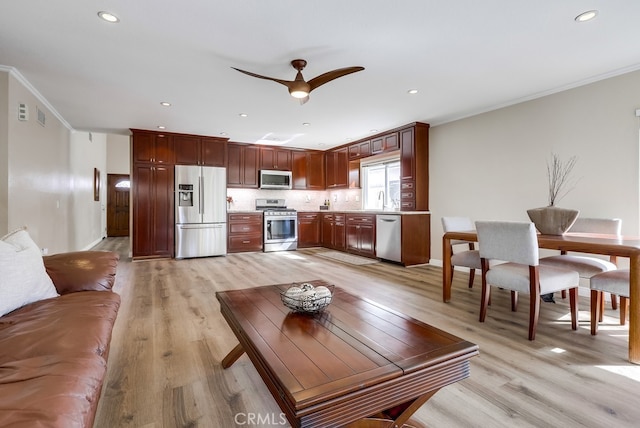 living room with ceiling fan, recessed lighting, light wood-type flooring, and ornamental molding