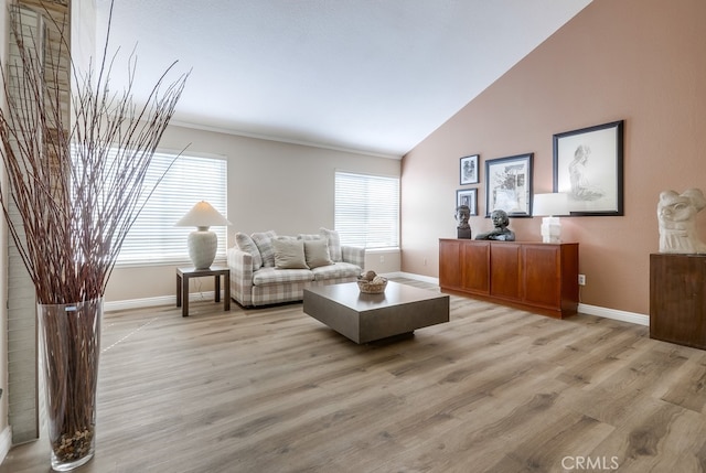 living room with light wood finished floors, baseboards, and lofted ceiling