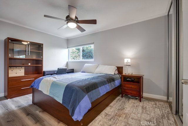 bedroom featuring light wood-type flooring, baseboards, and crown molding