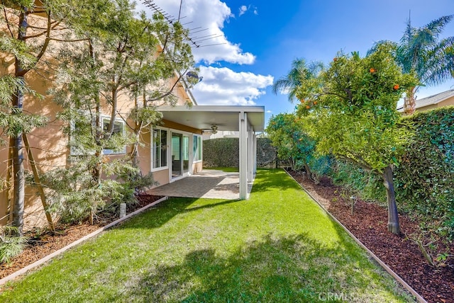 view of yard featuring a patio, a ceiling fan, and fence