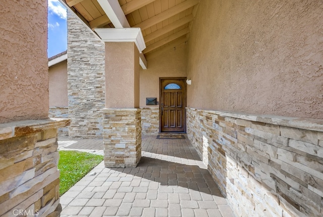 property entrance with stucco siding and stone siding