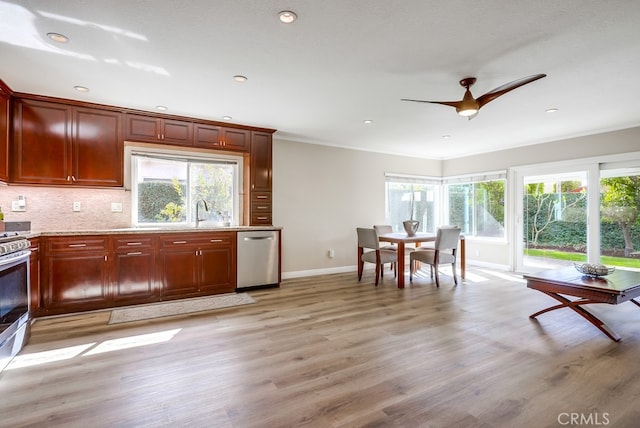 kitchen featuring light wood-style flooring, light stone counters, tasteful backsplash, appliances with stainless steel finishes, and ceiling fan